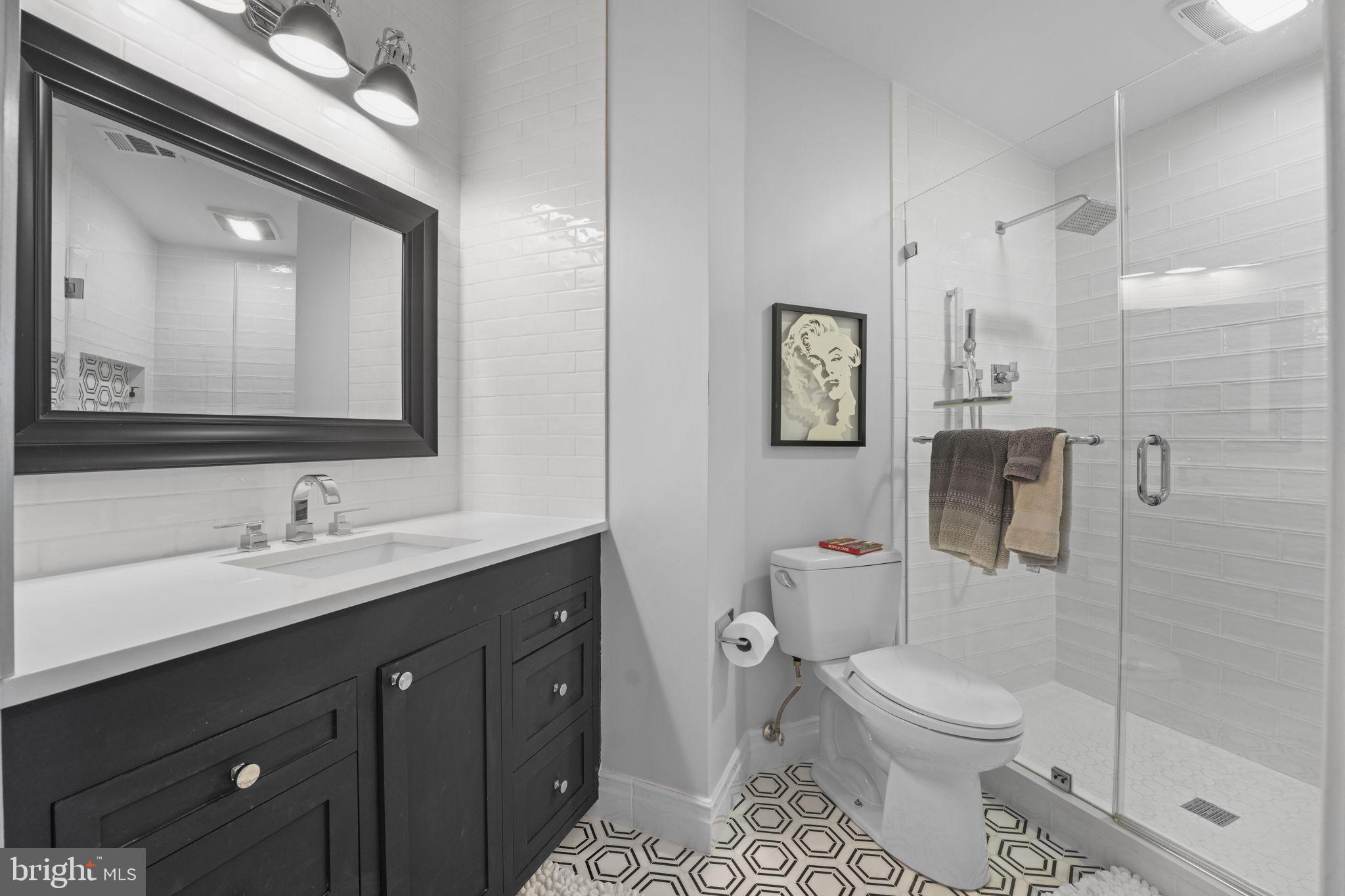 11431 Woolington Road Great Falls, VA 22066 - Photo 6 of 49 a bathroom with a toilet a sink a mirror and shower