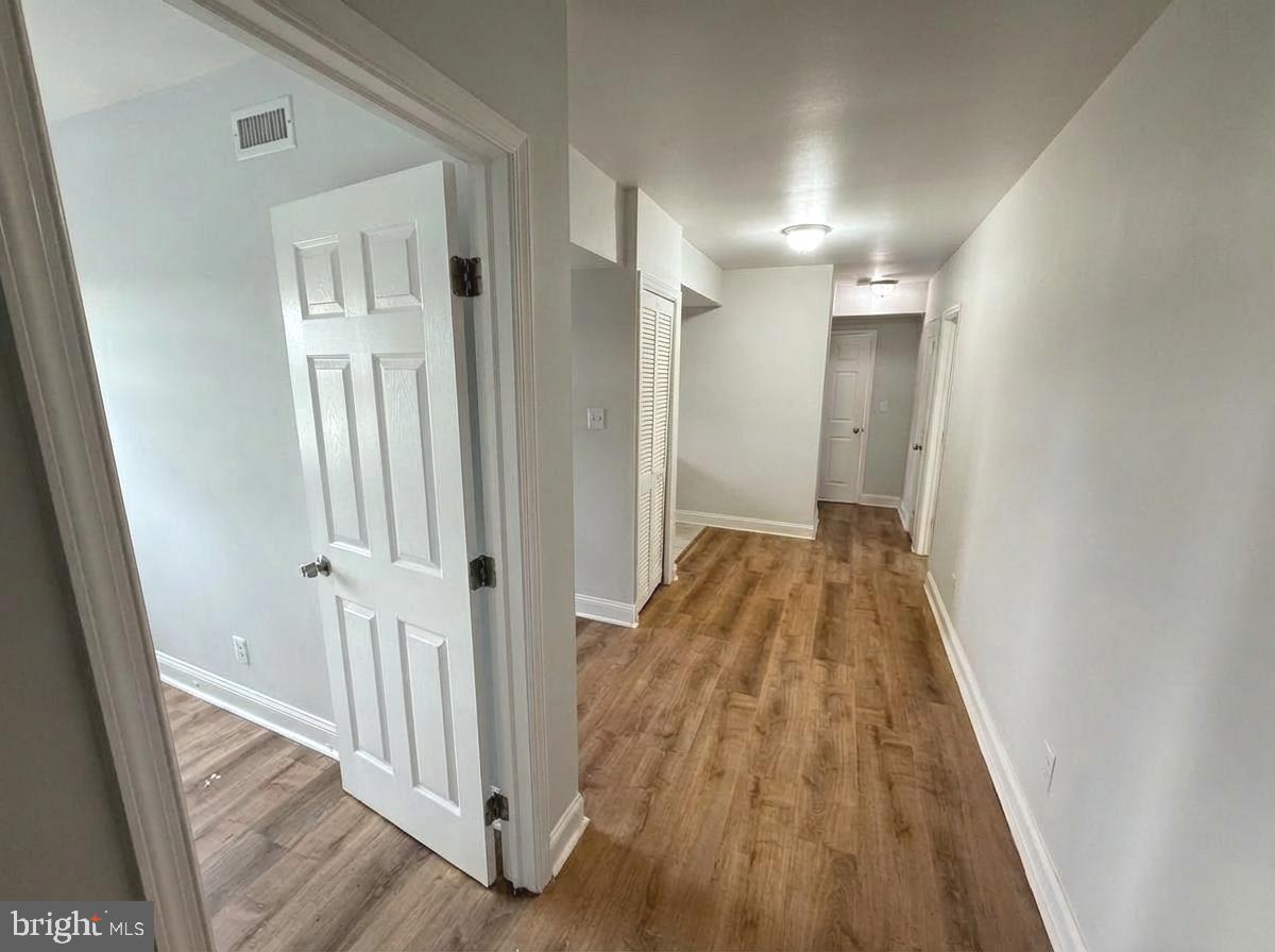 a view of a hallway with wooden floor and entryway