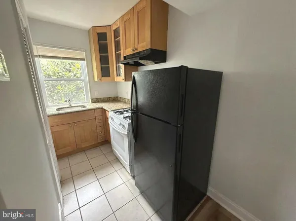 a kitchen with a refrigerator a stove a sink and a window