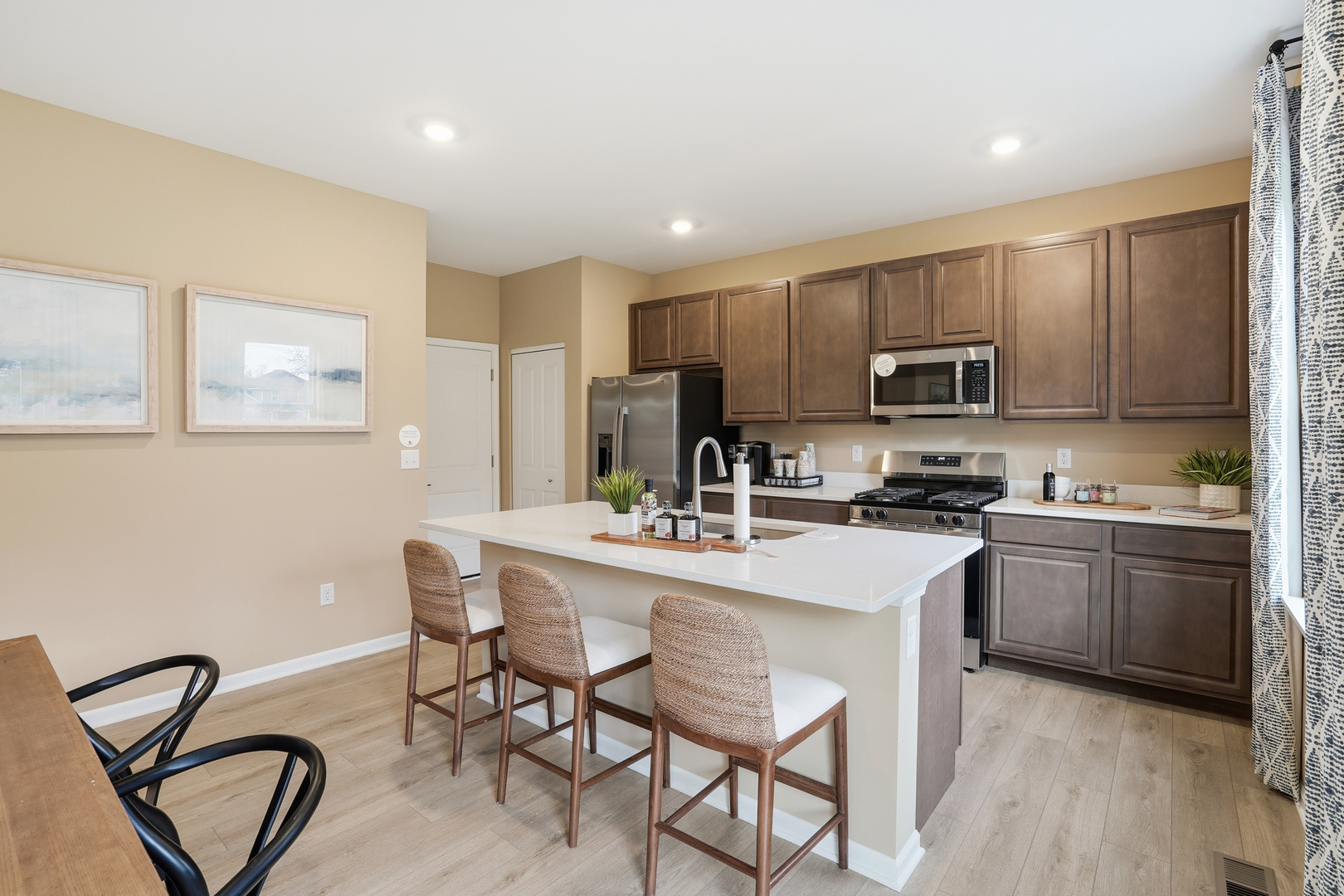 379 Danforth Drive Oswego, IL 60543 - Photo 5 of 20 a kitchen with kitchen island a stove a table and chairs
