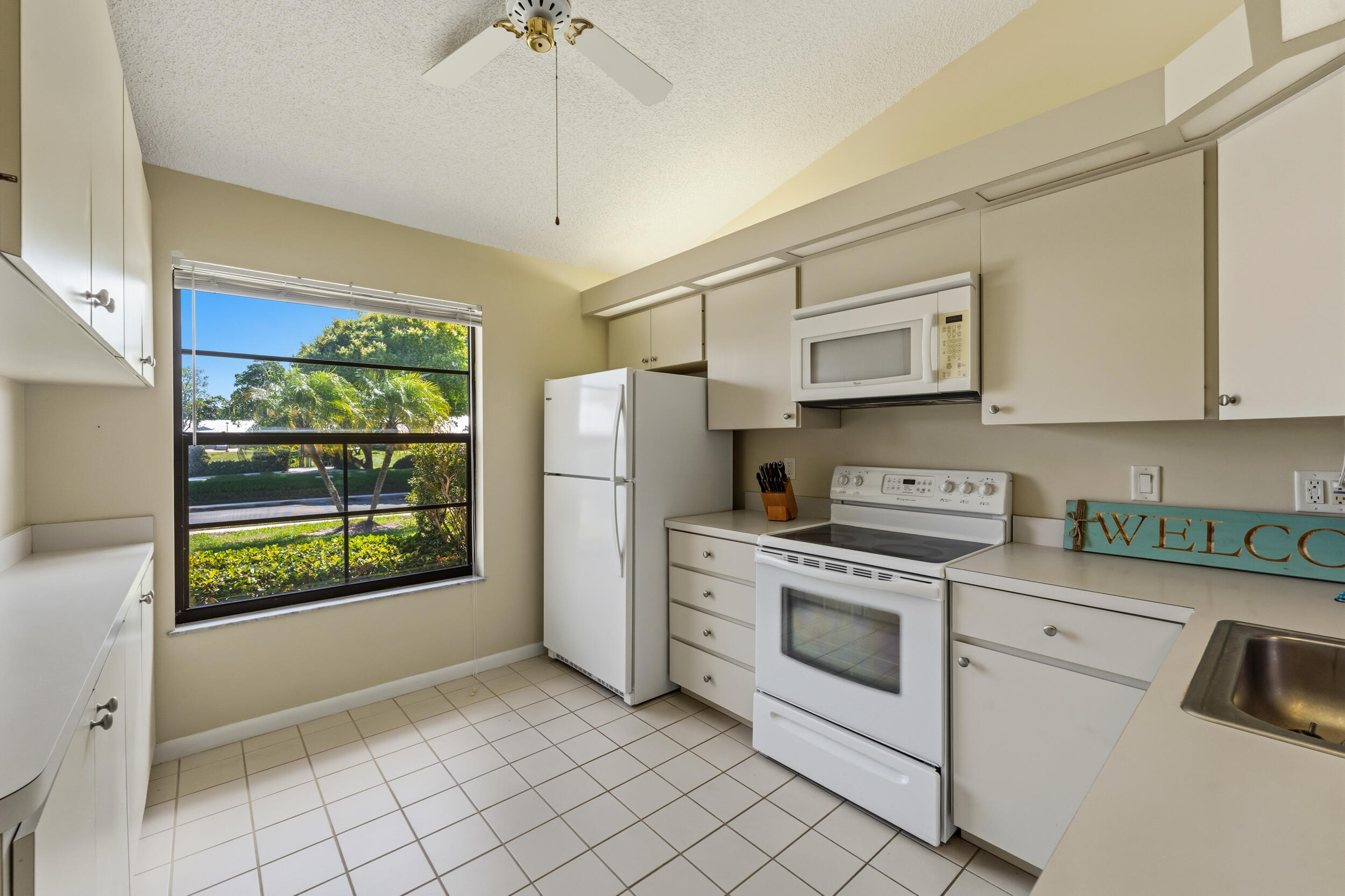 7873 Southeast Sugar Sand Circle Hobe Sound, FL 33455 - Photo 11 of 35 a kitchen with a stove a sink and a refrigerator