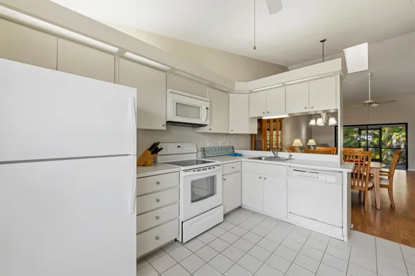 a kitchen with white cabinets and white appliances