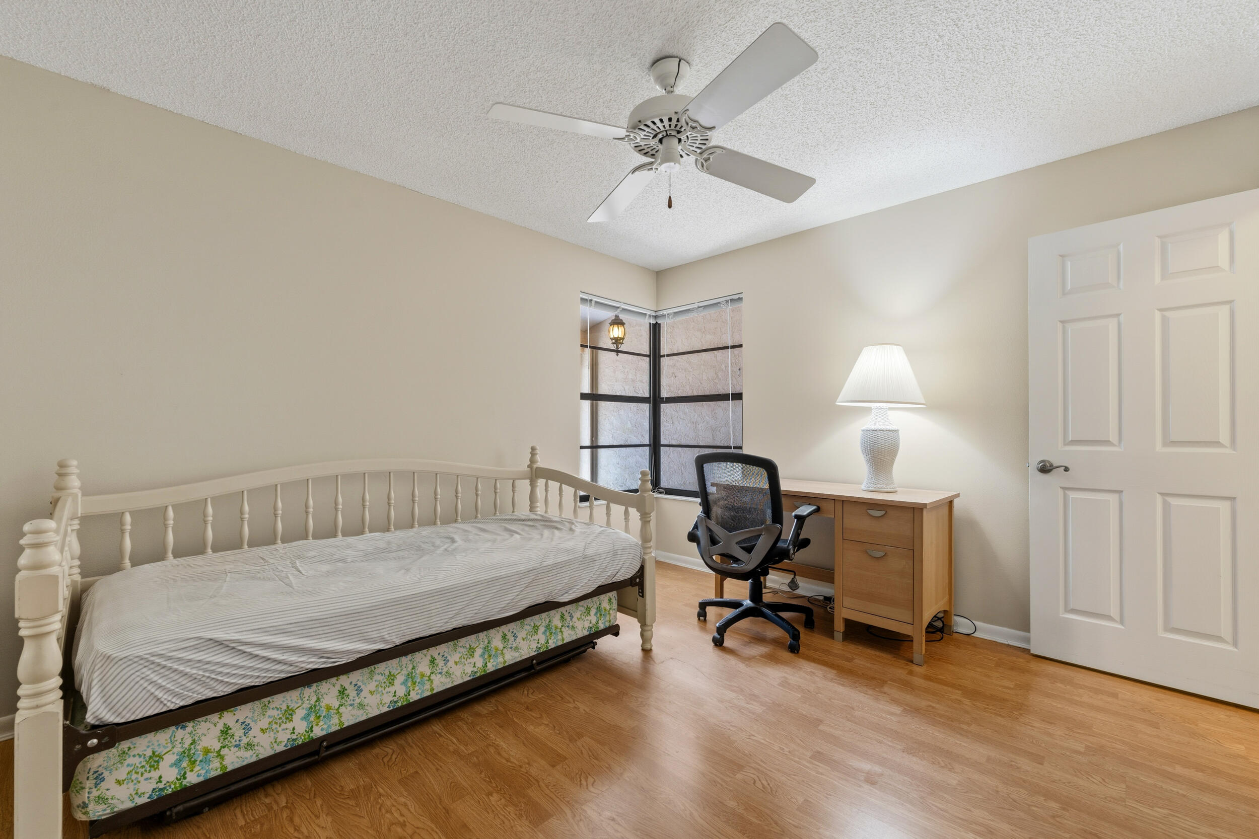7873 Southeast Sugar Sand Circle Hobe Sound, FL 33455 - Photo 21 of 35 a bedroom with a bed a desk and chair