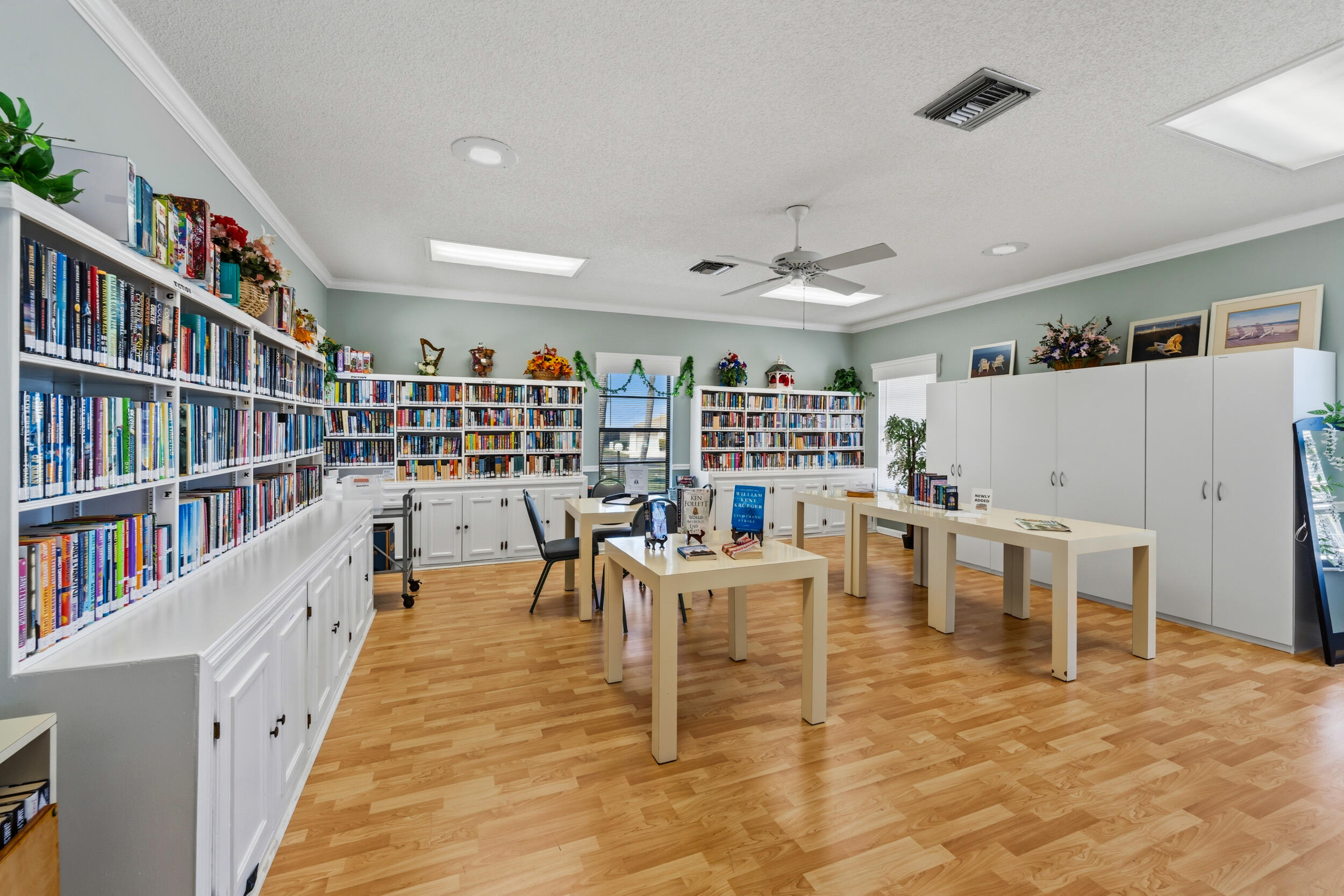 7873 Southeast Sugar Sand Circle Hobe Sound, FL 33455 - Photo 30 of 35 a living room with lots of furniture and a book shelf