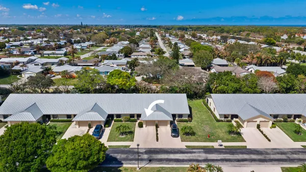 an aerial view of residential houses with outdoor space and parking