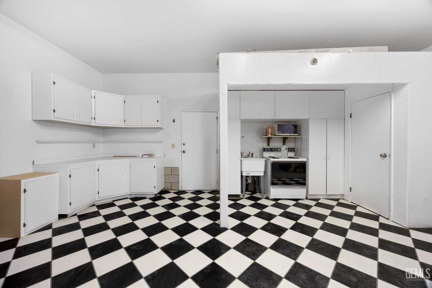 Undisclosed Address Wofford Heights, CA 93285 - Photo 24 of 26 a kitchen with a checkered floor and white cabinets