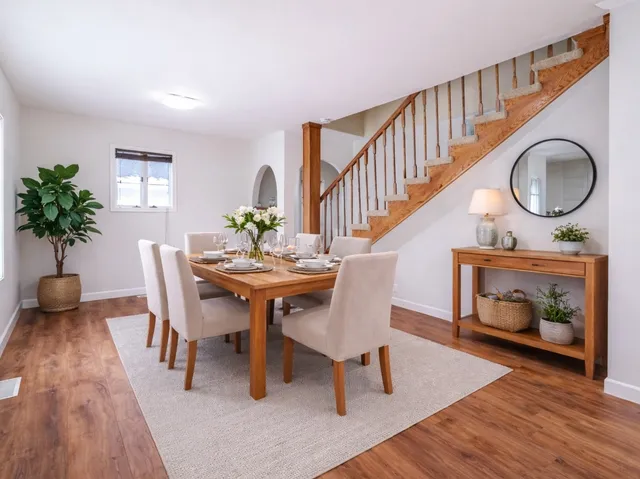 a dining room with furniture a fireplace and wooden floor