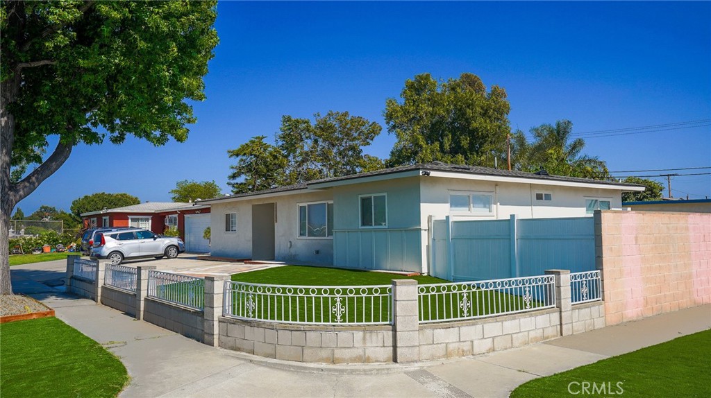 a view of a house with a backyard and a tree