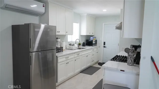a kitchen with stainless steel appliances a refrigerator sink and white cabinets