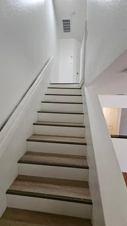 an empty room with wooden floor closet and windows