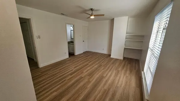 a view of empty room with wooden floor