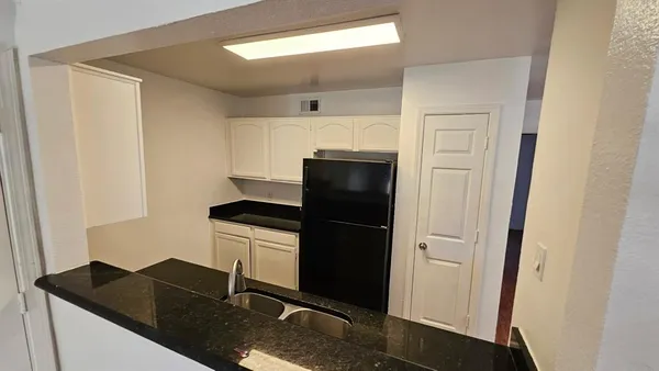 wooden floor in an empty room with a kitchen
