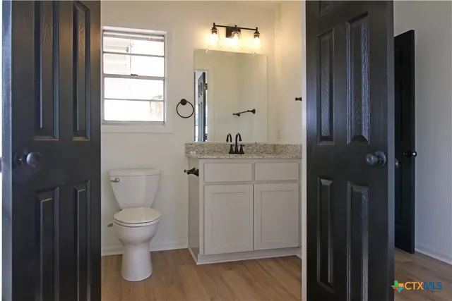 a bathroom with a toilet sink and mirror