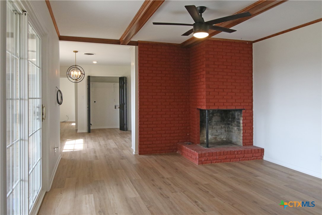 9681 Highway 53 Temple, TX 76501 - Photo 15 of 20 a view of a livingroom with wooden floor a fireplace and a window