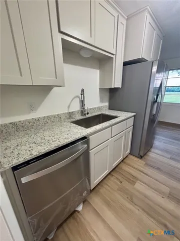 a kitchen with stainless steel appliances granite countertop a sink stove and cabinets