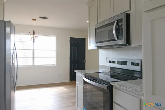 a kitchen with granite countertop a sink and a stove top oven