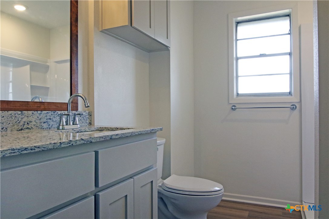 9681 Highway 53 Temple, TX 76501 - Photo 10 of 20 a bathroom with a granite countertop sink toilet and a mirror