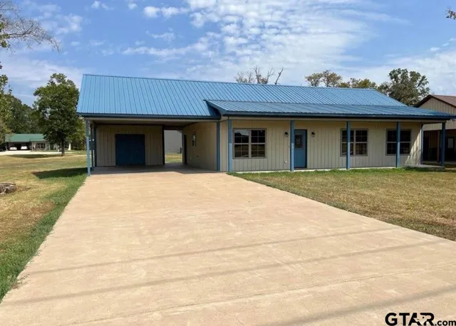 a view of a house with a yard and potted plants