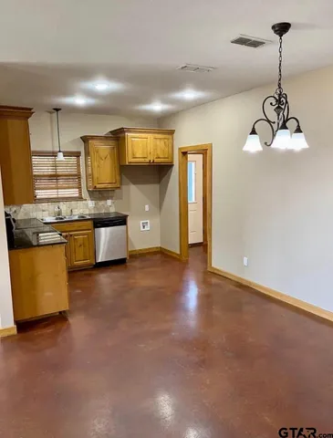 a view of kitchen with stainless steel appliances granite countertop stove top oven and cabinets
