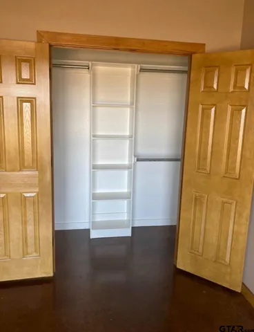 a view of walk in closet with empty racks