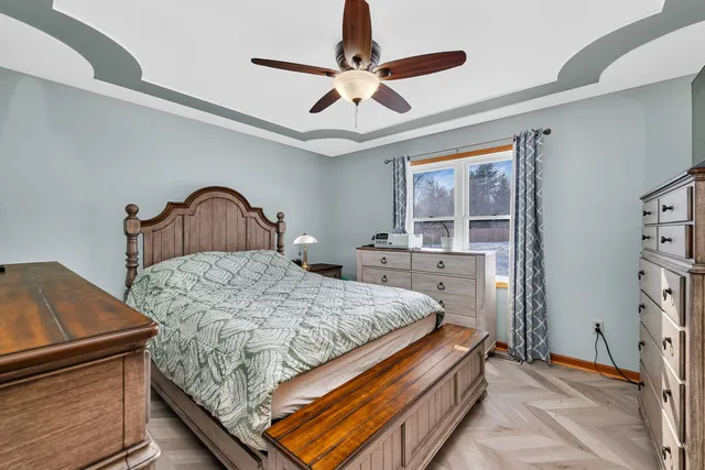 a bedroom with a bed dresser and a large window