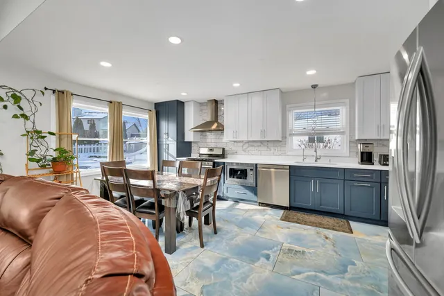 a kitchen with kitchen island granite countertop a sink stainless steel appliances and cabinets