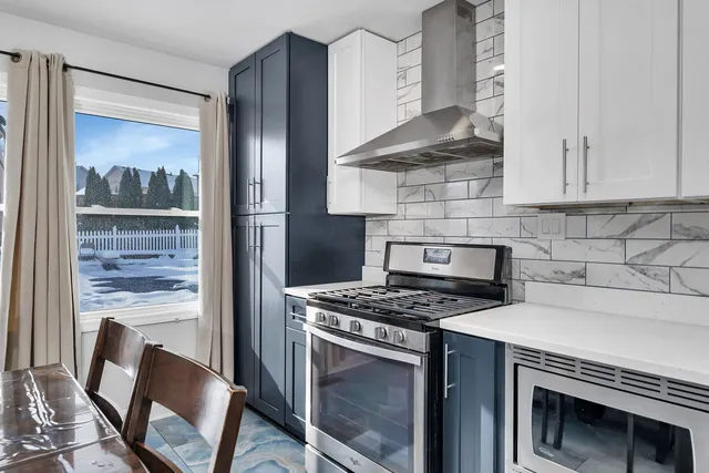 a kitchen with stainless steel appliances granite countertop a refrigerator a washer and dryer