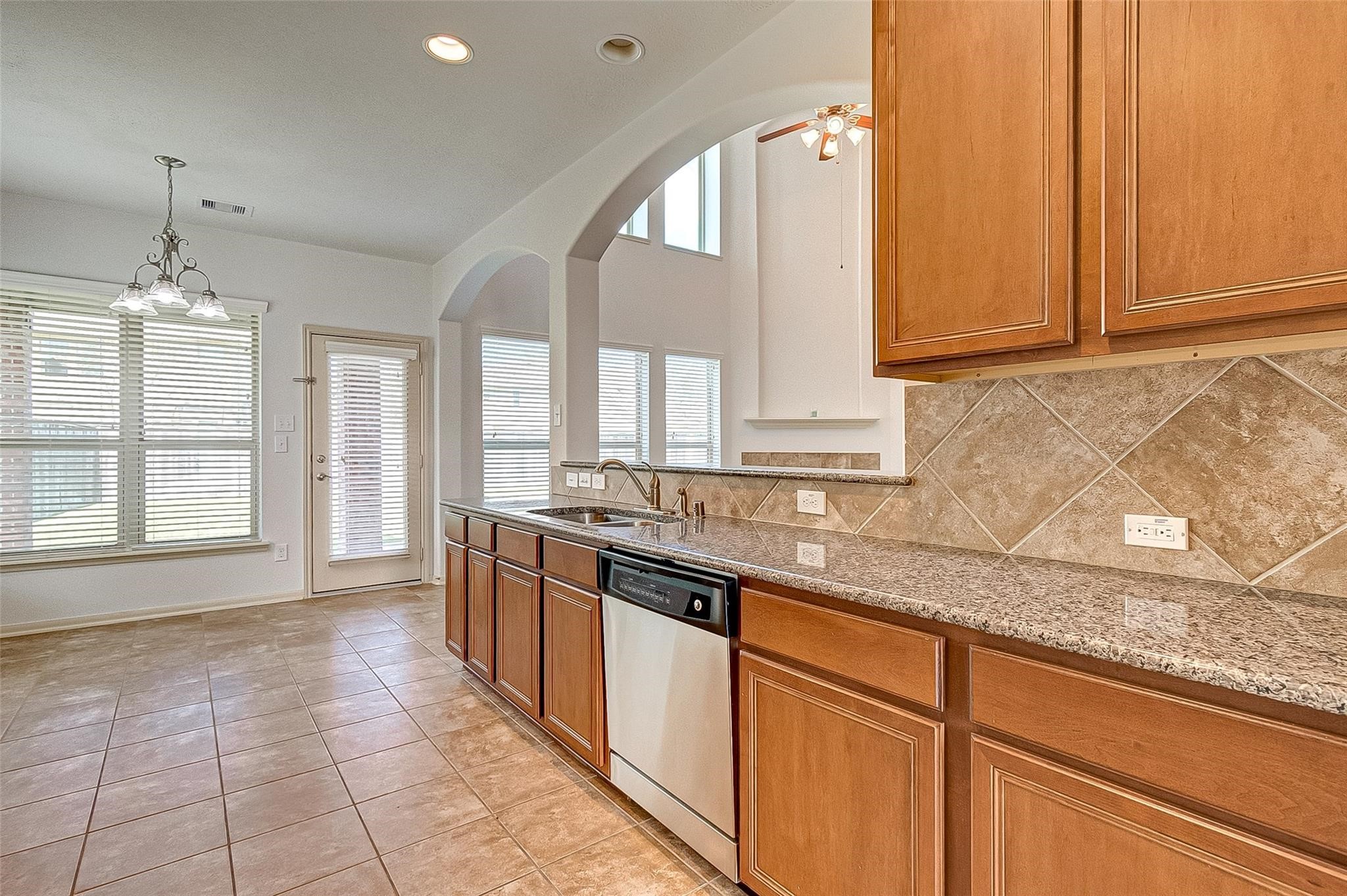 79 West Lasting Spring Circle Spring, TX 77389 - Photo 26 of 48 a large kitchen with granite countertop a stove a sink dishwasher and a granite counter top