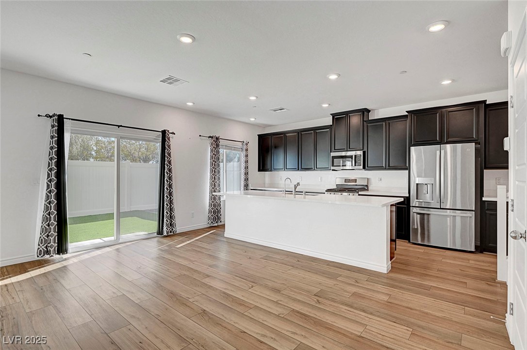7204 North Decatur Boulevard North Las Vegas, NV 89084 - Photo 17 of 55 Kitchen featuring light countertops, visible vents, light wood finished floors, recessed lighting, and appliances with stainless steel finishes