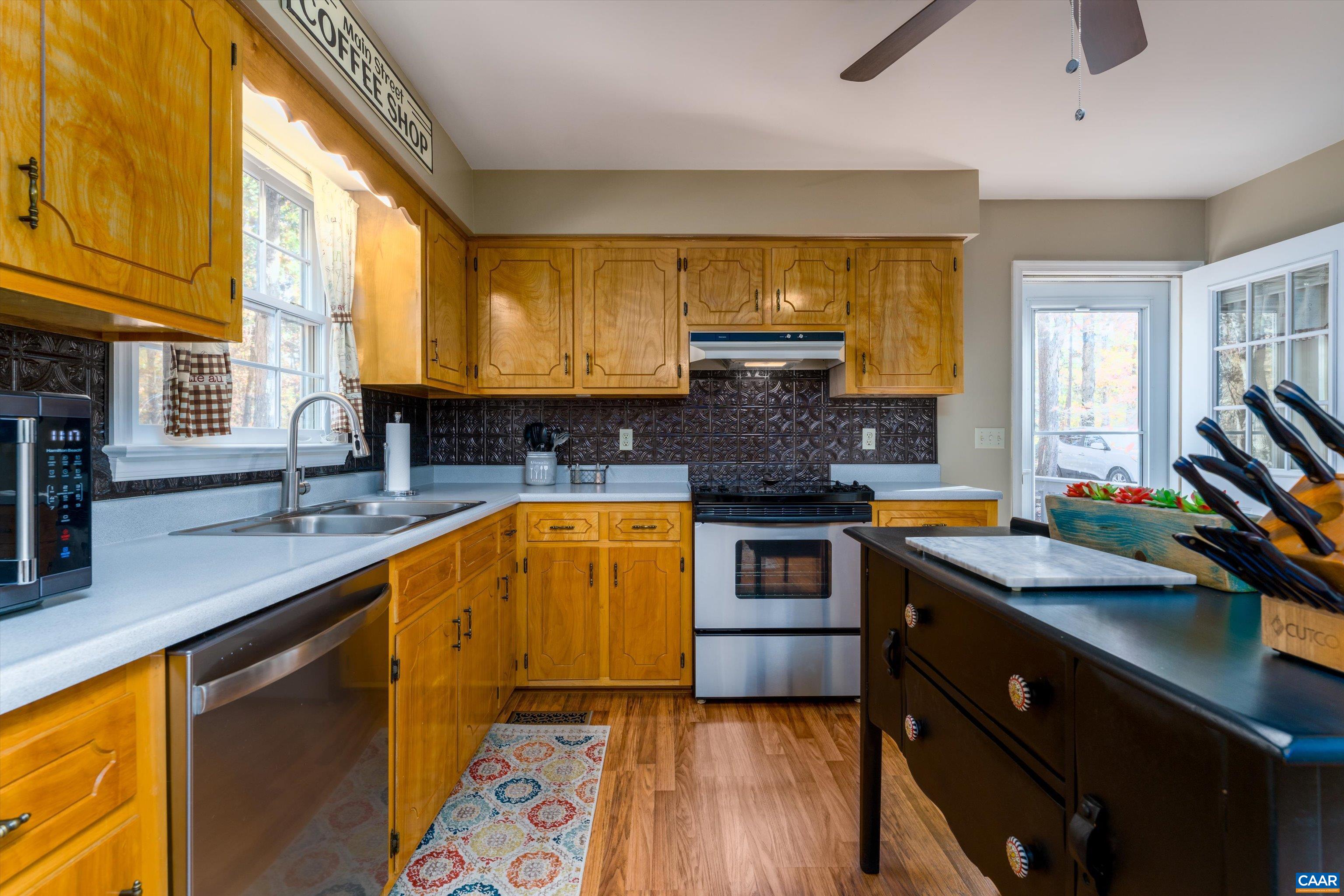 2321 Ruritan Lake Road Scottsville, VA 24590 - Photo 12 of 35 a kitchen with stainless steel appliances granite countertop a sink stove and cabinets