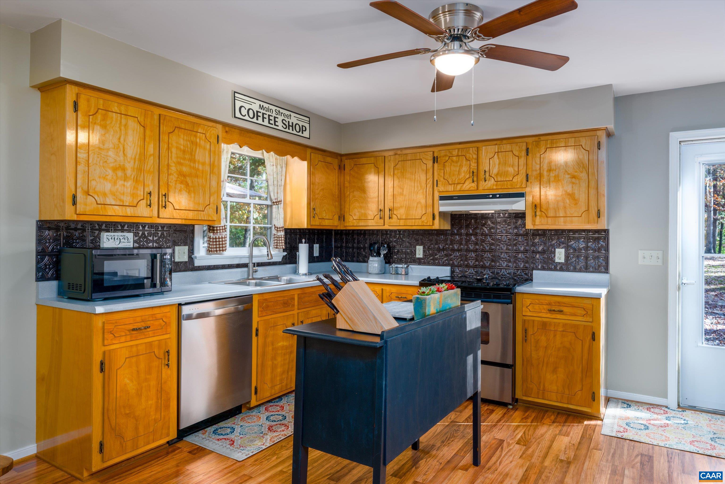 2321 Ruritan Lake Road Scottsville, VA 24590 - Photo 14 of 35 a kitchen with stainless steel appliances granite countertop sink stove and wooden floor