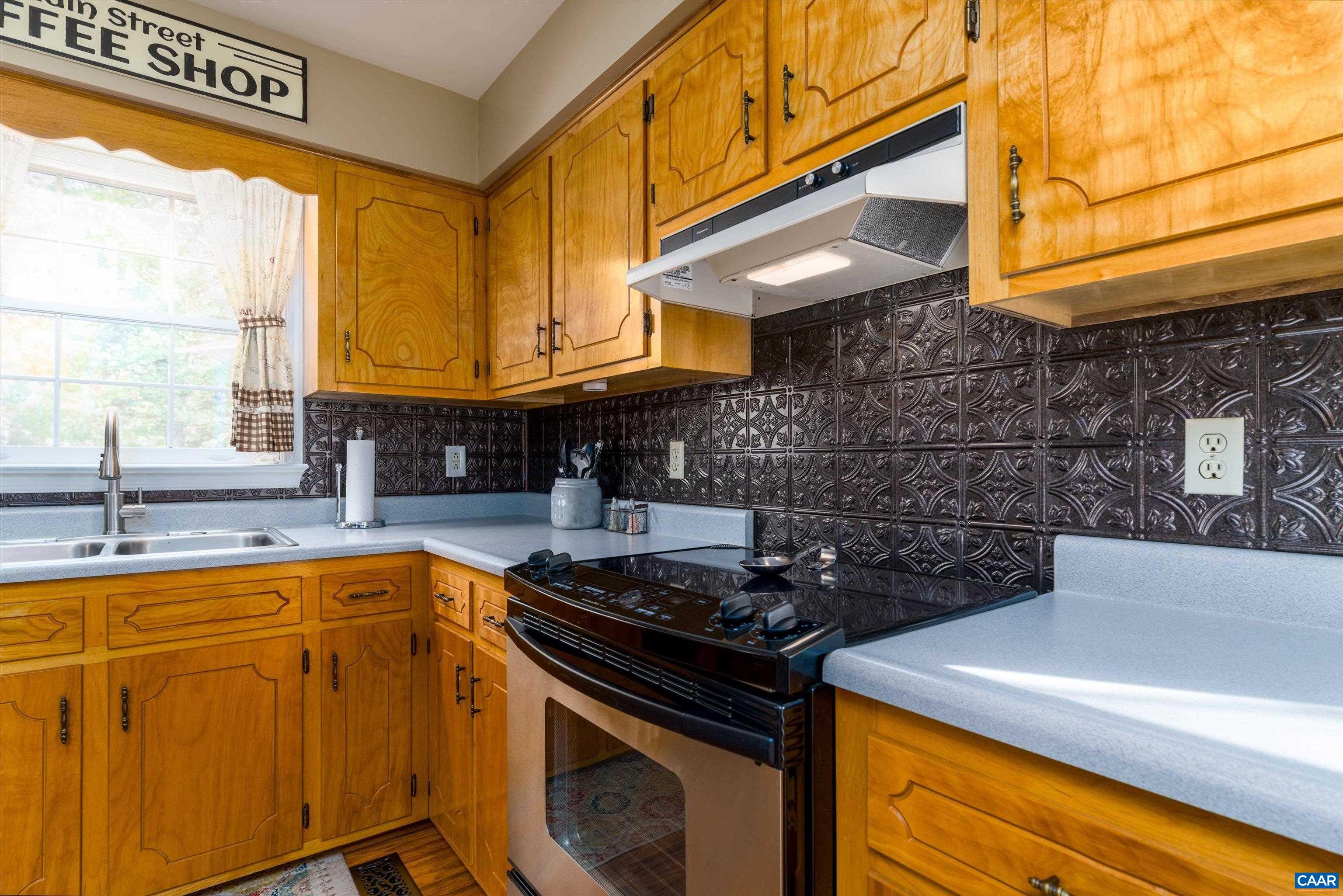 2321 Ruritan Lake Road Scottsville, VA 24590 - Photo 15 of 35 a kitchen with stainless steel appliances granite countertop a sink a stove and white cabinets
