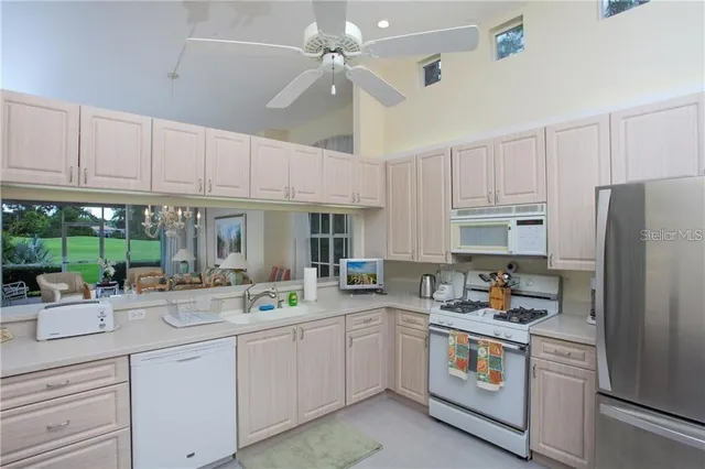 a kitchen with appliances a sink and cabinets