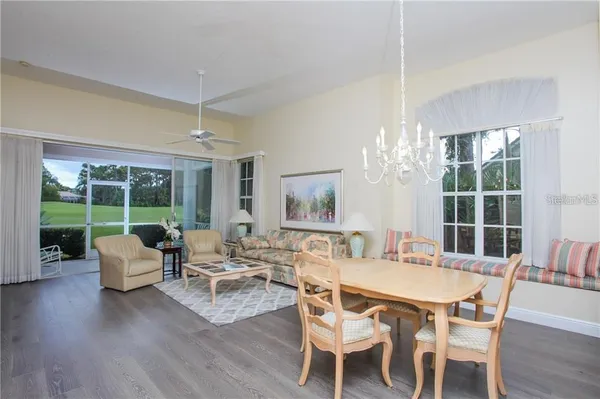 a dining room with furniture a chandelier and wooden floor