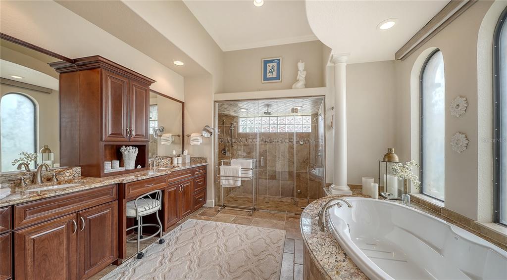 1630 Assisi Drive, Unit 18 Sarasota, FL 34231 - Photo 16 of 42 a spacious bathroom with a granite countertop tub sink a mirror a shower and vanity