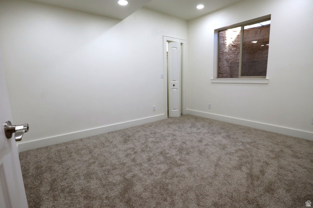 1055 North 1000 East Mapleton, UT 84664 - Photo 69 of 112 Room featuring neutral carpeting, white walls, recessed ceiling lighting, a window with a rock-lined outdoor area, and a white interior door