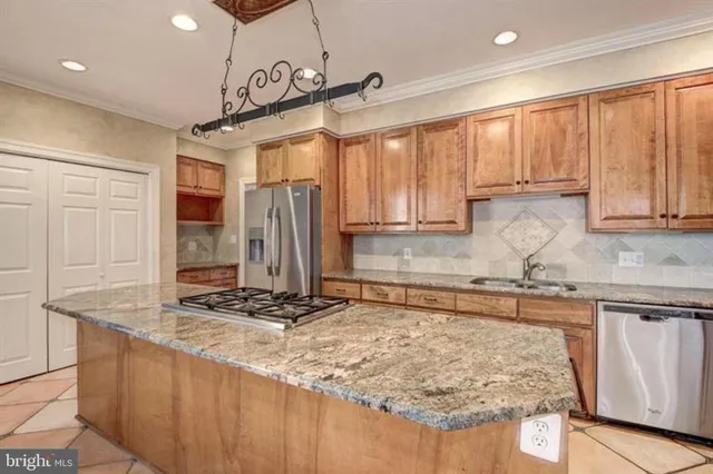 a kitchen with stainless steel appliances granite countertop a sink a stove and cabinets