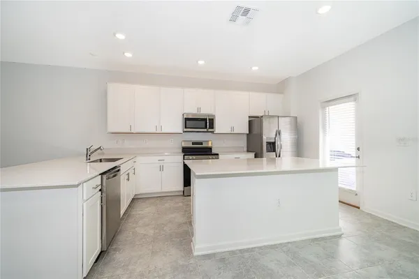 a kitchen with stainless steel appliances a sink stove and white cabinets