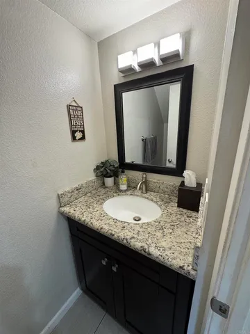 a bathroom with a granite countertop sink a mirror and vanity