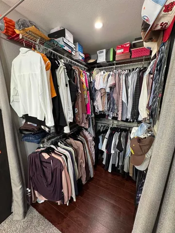 a view of walk in closet with clothes and shoes