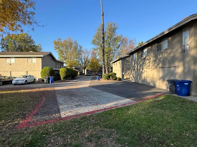 a view of road with house and car parked in front of it