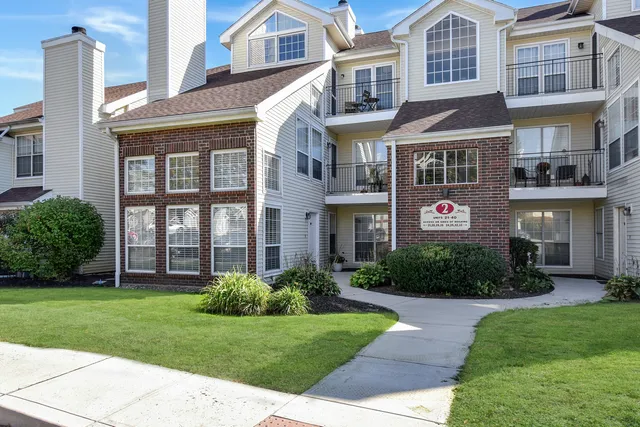 a front view of a brick building and yard with large windows