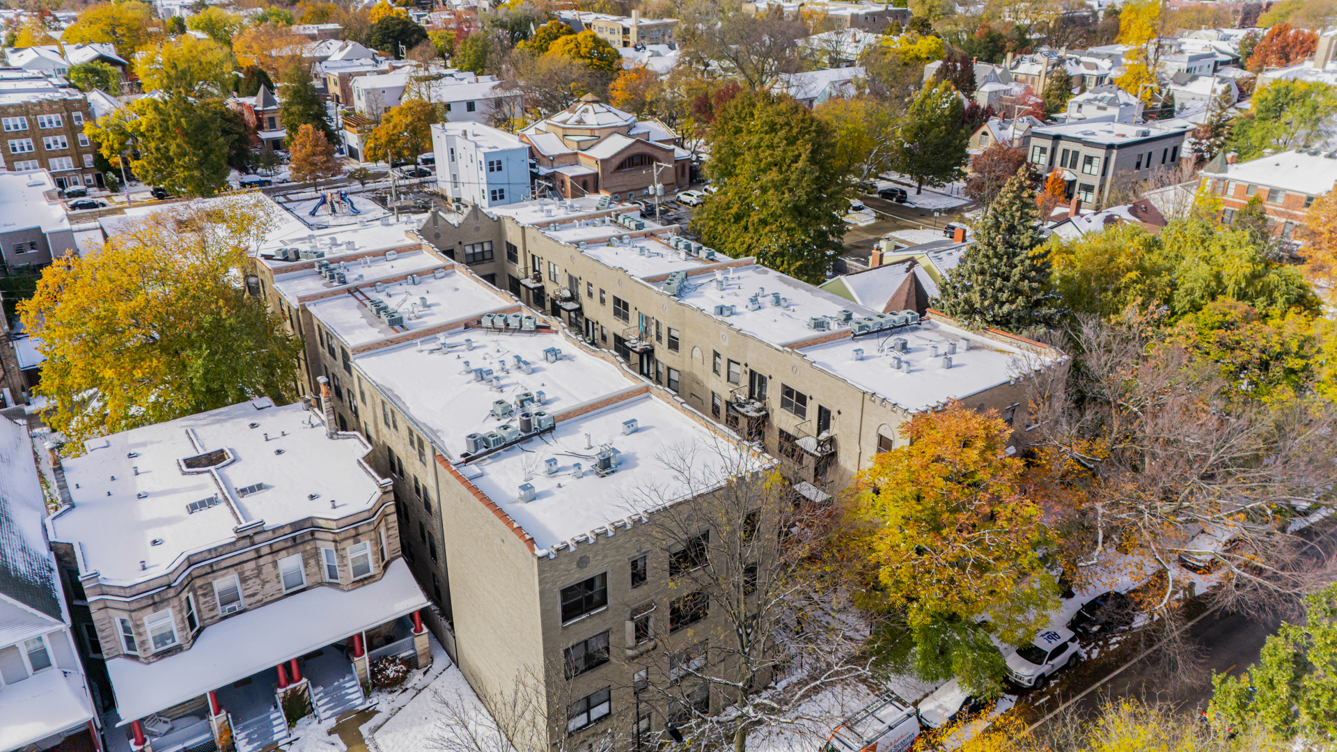 4444 North Damen Avenue, Unit 4E Chicago, IL 60625 - Photo 20 of 25 an aerial view of a residential apartment building with a yard and parking spaces