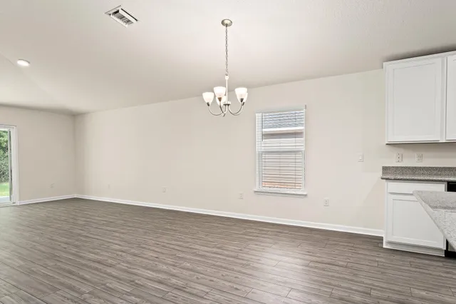 a view of a room with wooden floor and a ceiling fan