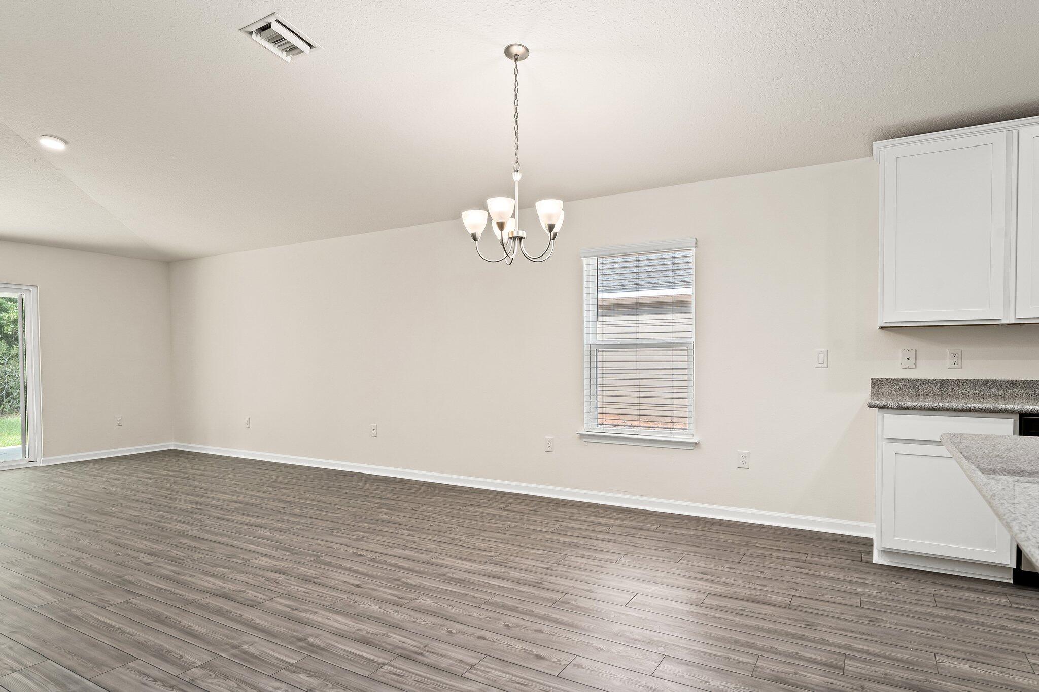 794 Riverwalk Circle Freeport, FL 32439 - Photo 18 of 31 a view of a room with wooden floor and a ceiling fan