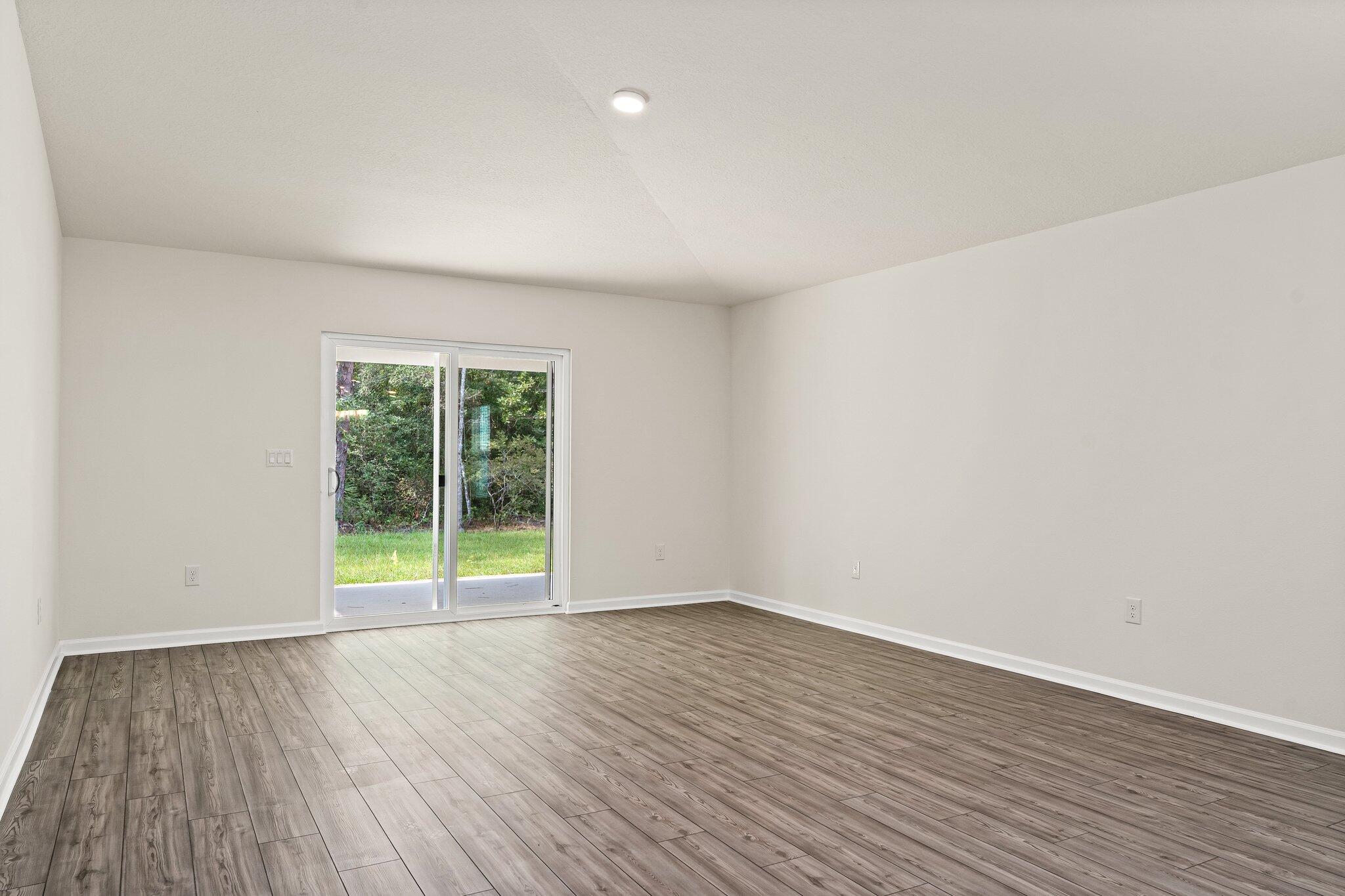 794 Riverwalk Circle Freeport, FL 32439 - Photo 20 of 31 a view of an empty room with wooden floor and a window