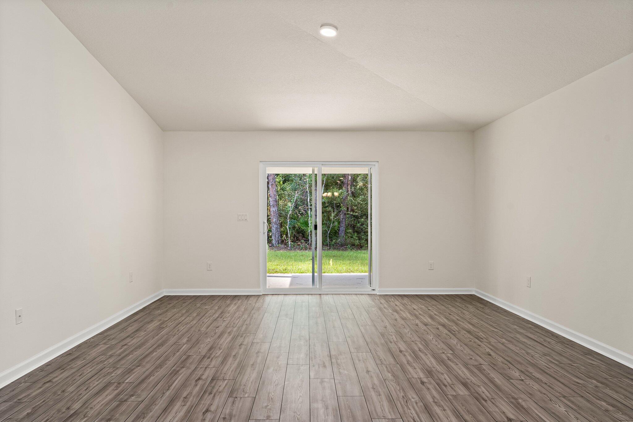 794 Riverwalk Circle Freeport, FL 32439 - Photo 21 of 31 a view of an empty room with wooden floor and a window