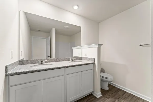 a bathroom with a granite countertop sink a toilet and a mirror