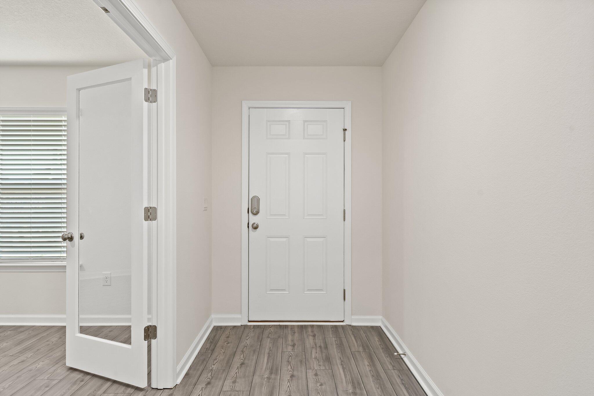 794 Riverwalk Circle Freeport, FL 32439 - Photo 4 of 31 an empty room with wooden floor and windows