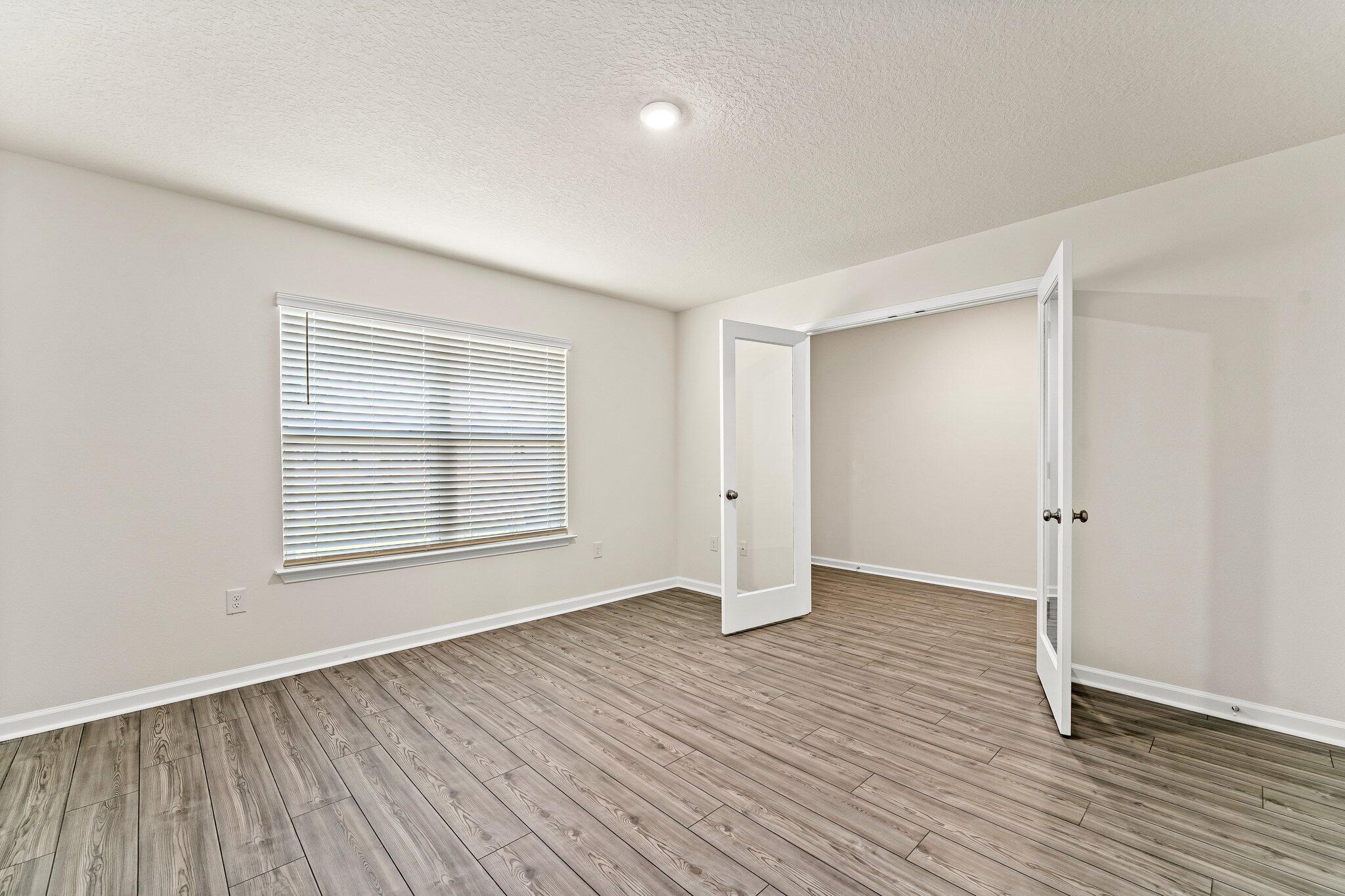 794 Riverwalk Circle Freeport, FL 32439 - Photo 6 of 31 an empty room with wooden floor and windows